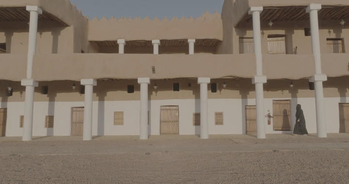 امرأة تمشي في اروقة قصر القشلة في حائل، تصوير نهاري.