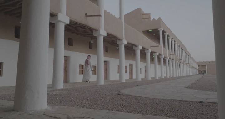 رجل يمشي في اروقة قصر القشلة في حائل، تصوير بزاوية منخفضة.