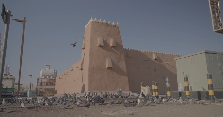 قصر القشلة في حائل مع حمام في المقدمة، لقطة نهارية.