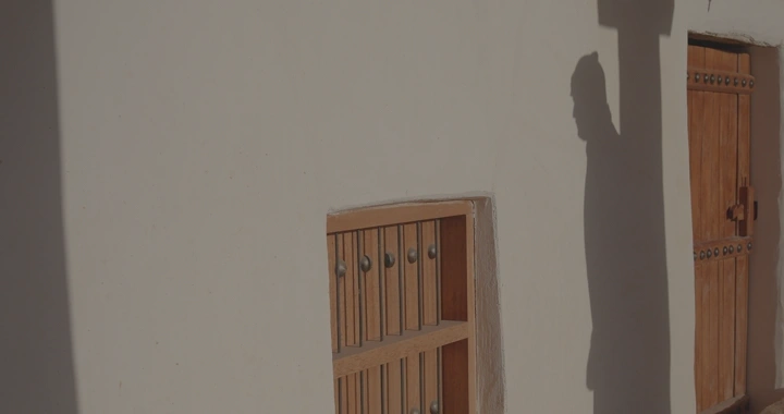 ظل رجل يمشي بجانب جدار قصر القشلة في حائل، لقطة نهارية.