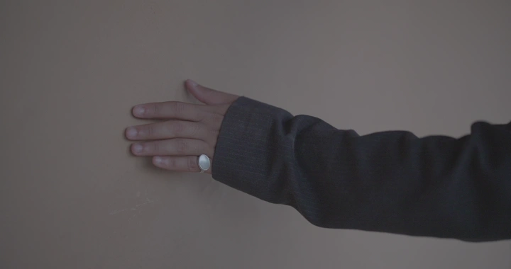 يد تلمس جدار طيني، لقطة قريبة.