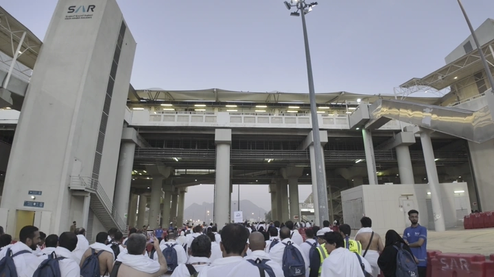 حجاج يسيرون نحو جسر الجمرات في مشعر منى، لقطة أرضية.