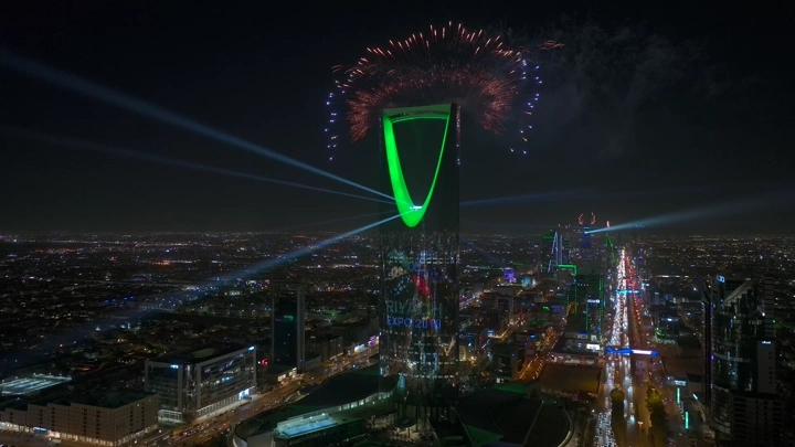 الألعاب النارية فوق برج المملكة في الرياض ليلاً، لقطة جوية.