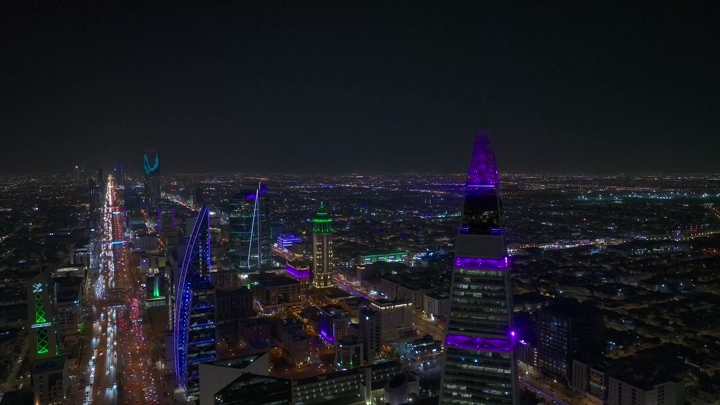 مدينة الرياض ليلاً مع برج الفيصلية مضاء، لقطة جوية.