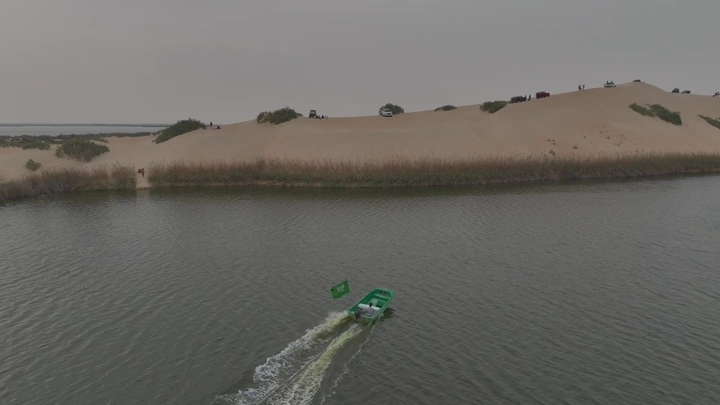 قارب يحمل علم السعودية في بحيرة الأصفر، تصوير جوي.