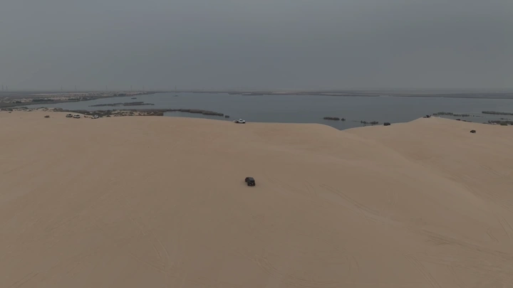 بحيرة الأصفر في الأحساء مع سيارات على الرمال، صورة جوية.