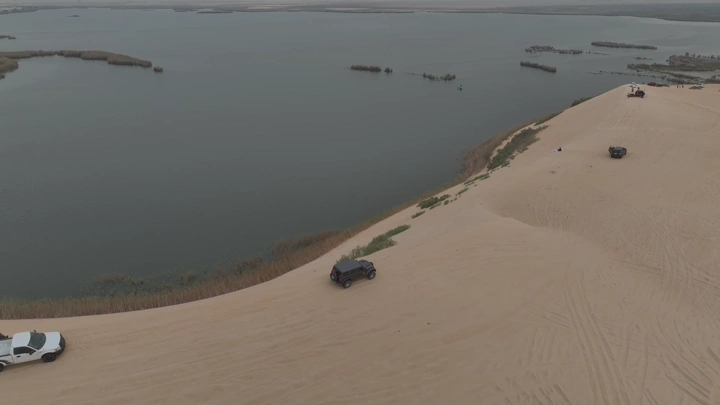 بحيرة الأصفر في الأحساء مع سيارات على الكثبان الرملية، لقطة جوية.