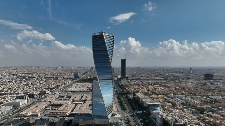 برج مجدول في الرياض تحت سماء زرقاء، لقطة جوية.