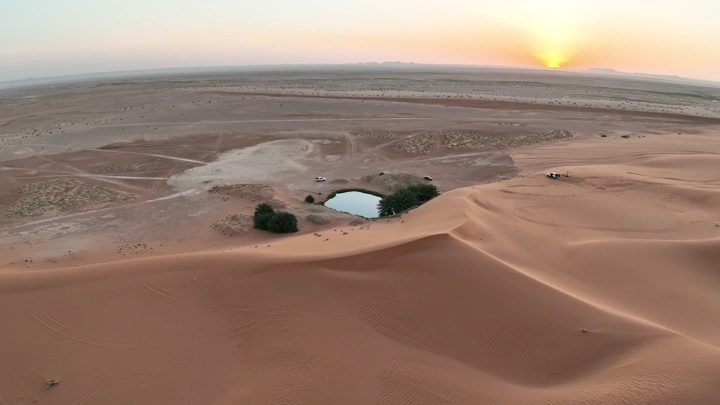 بحيرة صغيرة في الصحراء عند غروب الشمس، لقطة جوية.