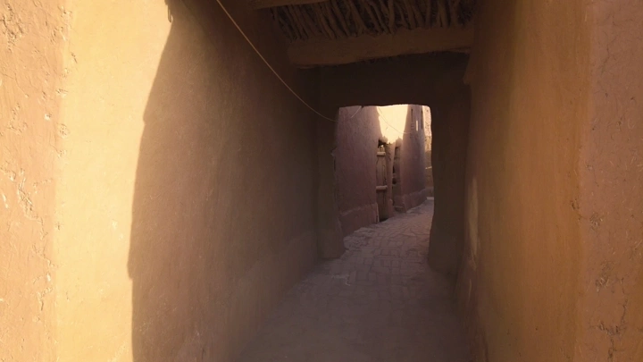ممر ضيق في قرية أشيقر التراثية بالرياض، لقطة في ضوء النهار.