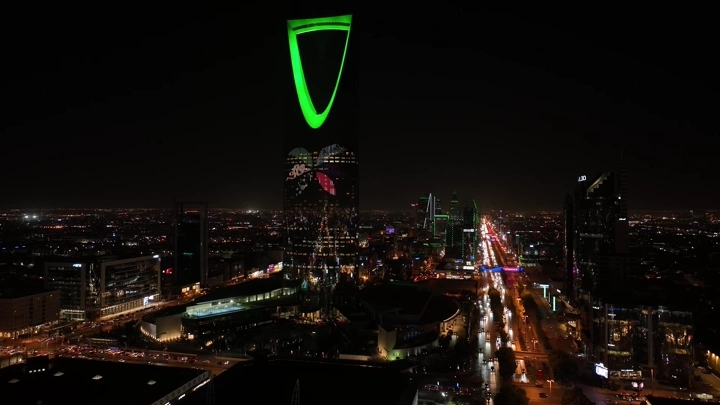 برج المملكة في الرياض ليلاً بإضاءة خضراء، لقطة جوية.