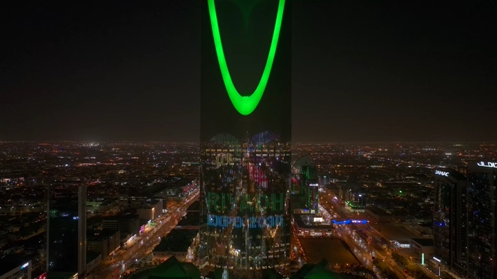 برج المملكة في الرياض ليلاً بإضاءة خضراء، لقطة جوية.