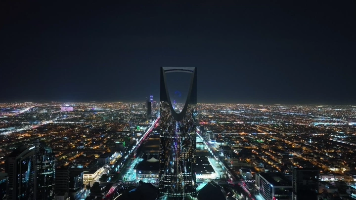 برج المملكة مضاء في الرياض ليلاً، لقطة جوية.