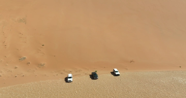 سيارات دفع رباعي على كثبان رملية في الربع الخالي، لقطة جوية.