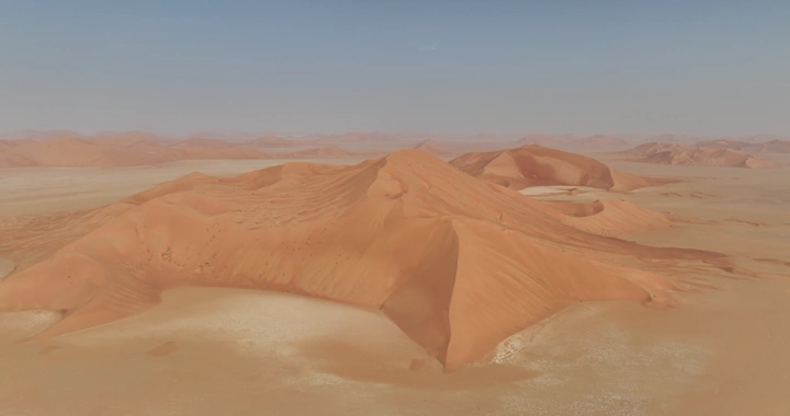 كثبان رملية في الربع الخالي تحت السماء الصافية، منظر جوي.