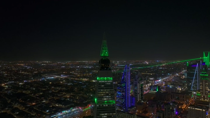 برج الفيصلية مضاء ليلاً في الرياض، لقطة جوية.