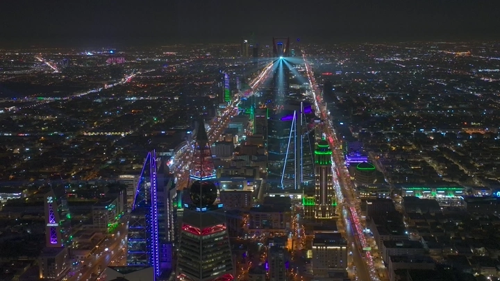 أفق الرياض ليلاً مع برج المملكة والفيصلية، لقطة جوية.