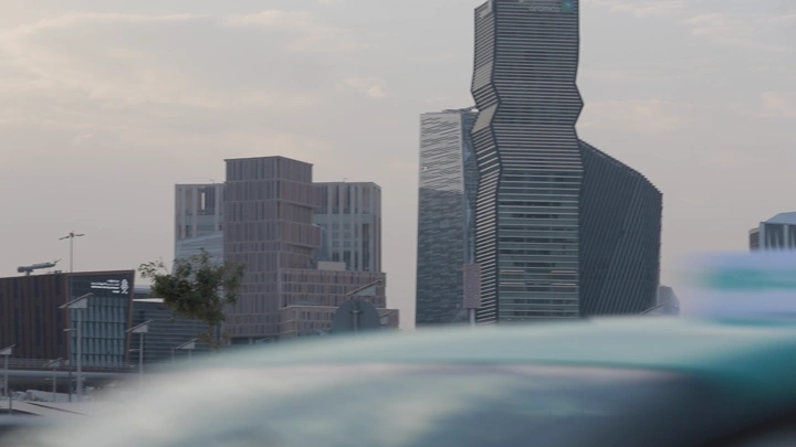 المركز المالي في الرياض مع سيارات في المقدمة، لقطة من مستوى الشارع.