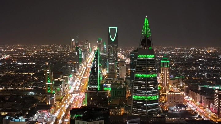 منظر جوي ليلي لطريق الملك فهد في الرياض، إضاءة المباني الخضراء. لقطة جوية