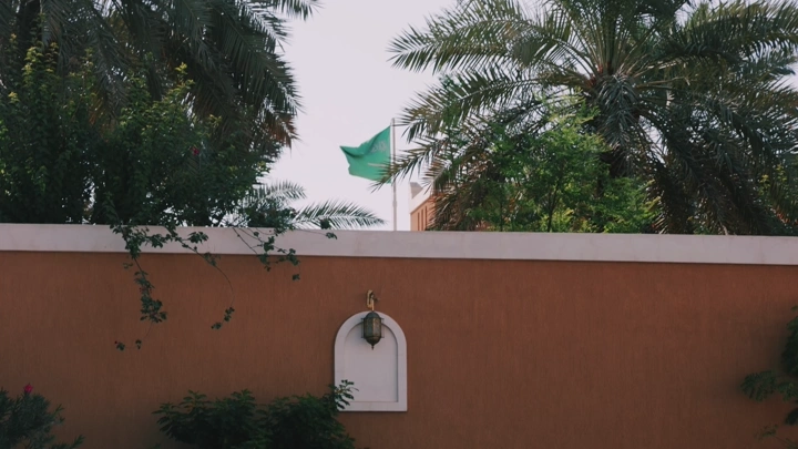 علم السعودية يرفرف فوق جدار بيت شعبي، لقطة نهارية.