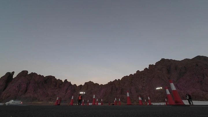 سيارة رياضية تؤدي حركة درفت بسرعة على مضمار في منطقة جبلية، مع تصاعد دخان الإطارات، لقطة FPV.