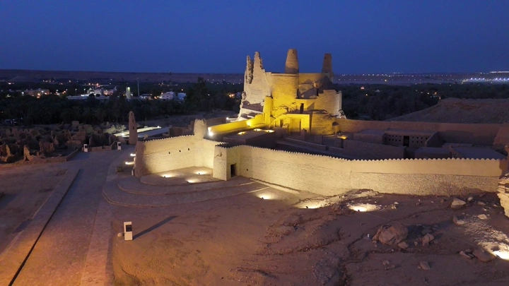 قلعة مارد الأثرية بمدينة دومة الجندل بمنطقة الجوف مضاءة ليلاً، لقطة جوية.