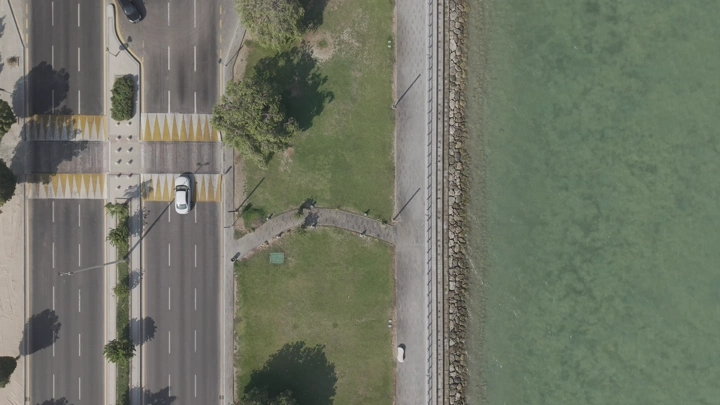 لقطة جوية للكورنيش في مدينة الخبر، تُظهر الطريق والممشى بجانب البحر.