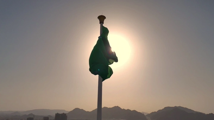 علم يرفرف أمام الشمس في السعودية، تصوير جوي درون.